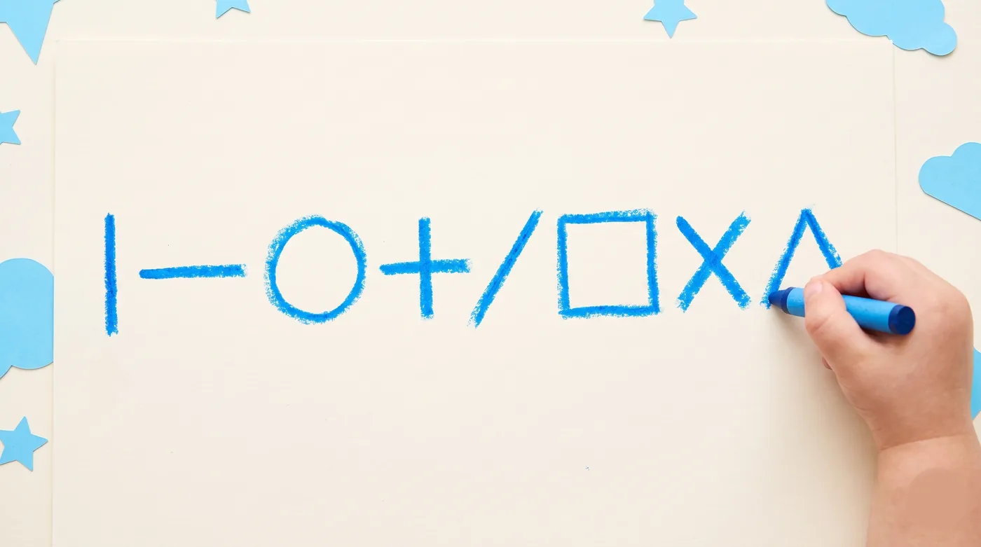 The nine pre-writing shapes drawn in bright blue crayon as a child completes the final triangle